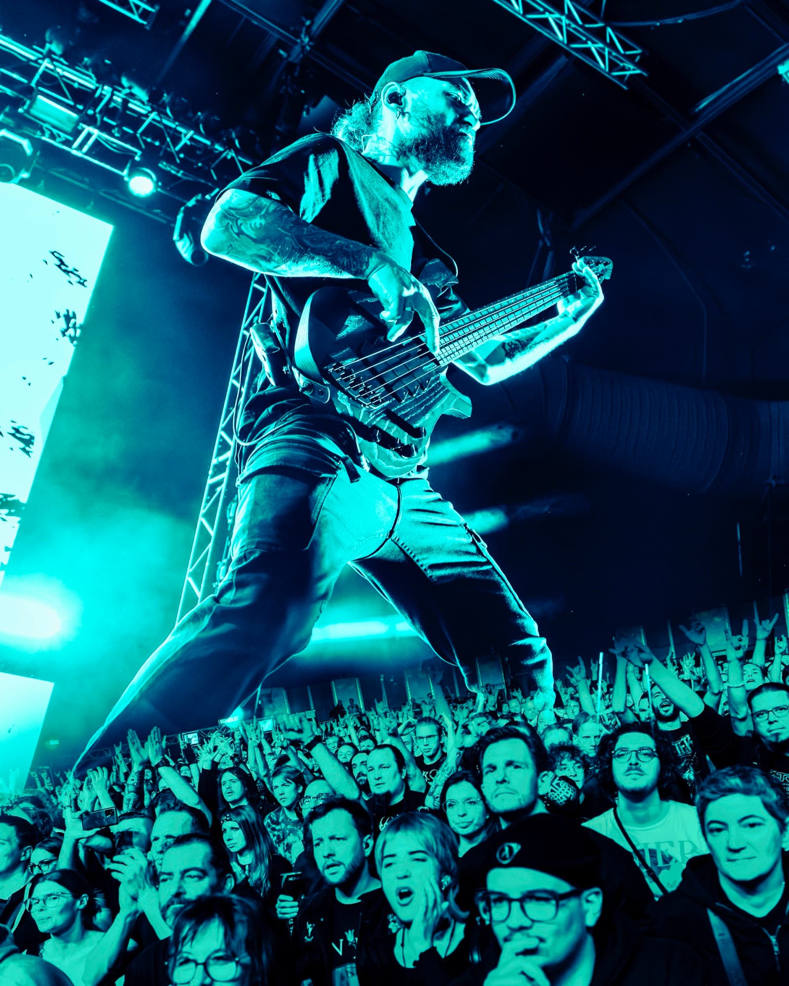 Jinjer bassist towering over crowd in blue light