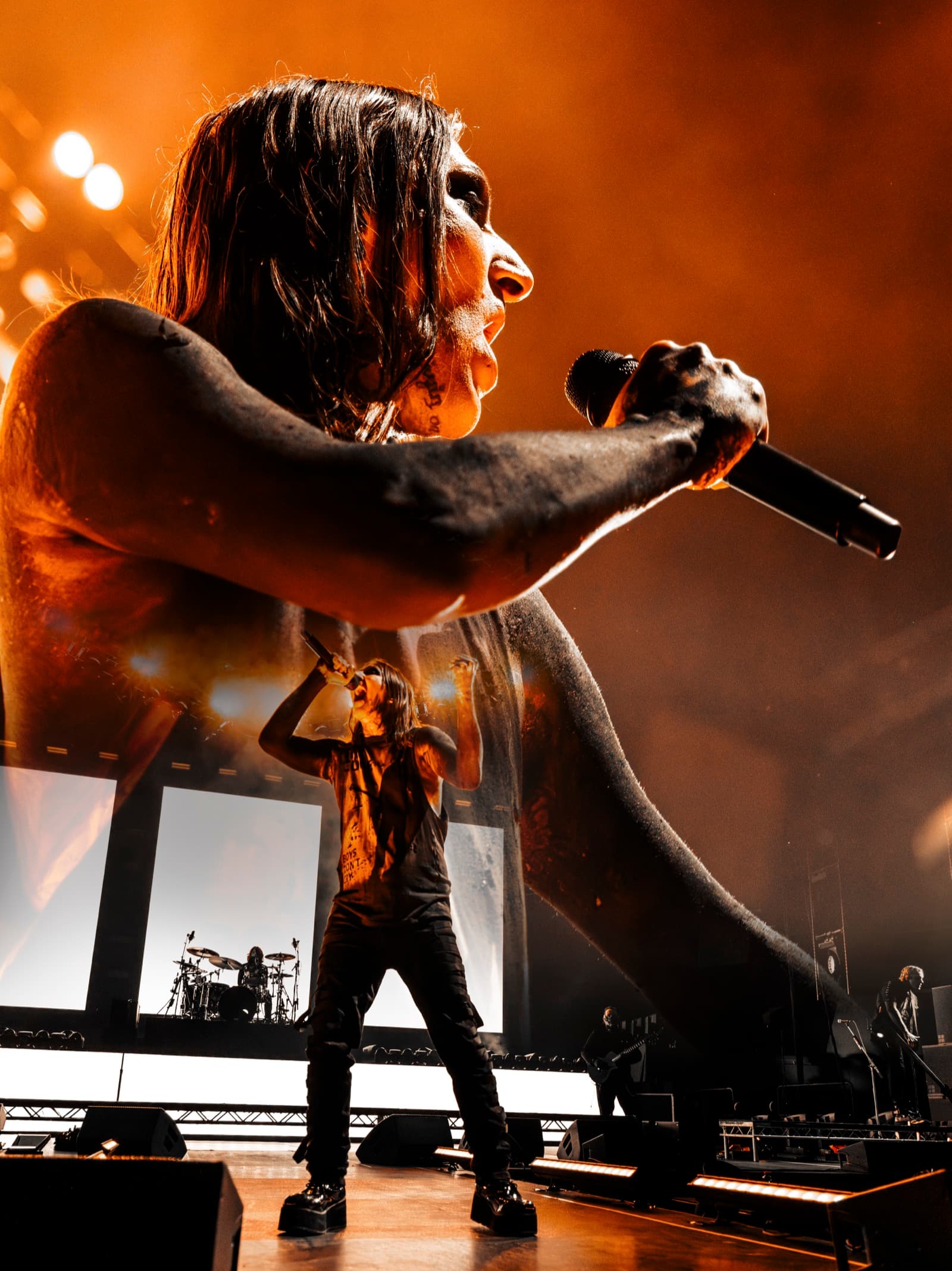 Chris Motionless singing profile in orange stage light